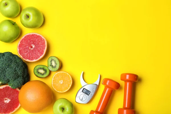 黄色背景下的水果 哑铃和数码卡尺 平铺着文字空间 访问营养师 — 图库照片