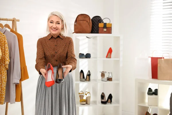 Власник жіночого бізнесу показує взуття в бутіку. Простір для тексту — стокове фото