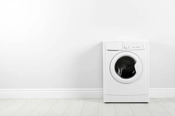 Beyaz duvarın yanında modern çamaşır makinesi, yazı için yer var. Çamaşır. — Stok fotoğraf