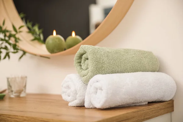 Serviettes fraîches sur table en bois dans la salle de bain — Photo