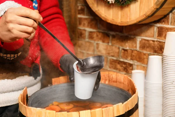 Verkäufer gießt bei Winterfai leckeren aromatischen Glühwein in Tasse — Stockfoto