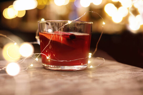 Tasty aromatic mulled wine on wooden table