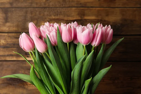 Lindas tulipas de primavera rosa no fundo de madeira — Fotografia de Stock