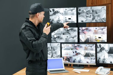 Mobil vericili güvenlik görevlisi modern CCTV 'yi izliyor. 