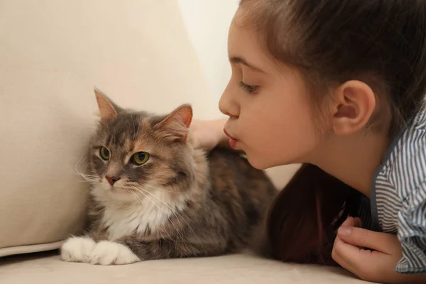 Jolie petite fille avec chat sur le canapé à la maison. Premier animal de compagnie — Photo