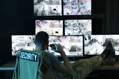 Mobil vericili güvenlik görevlisi modern CCTV 'yi izliyor. 