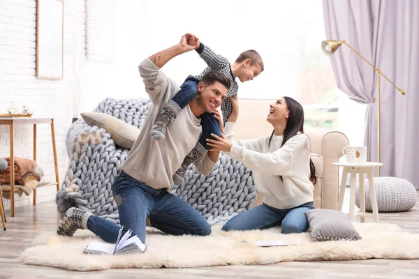 Familia feliz con su pequeño hijo divirtiéndose en casa. Vacaciones de invierno — Foto de Stock