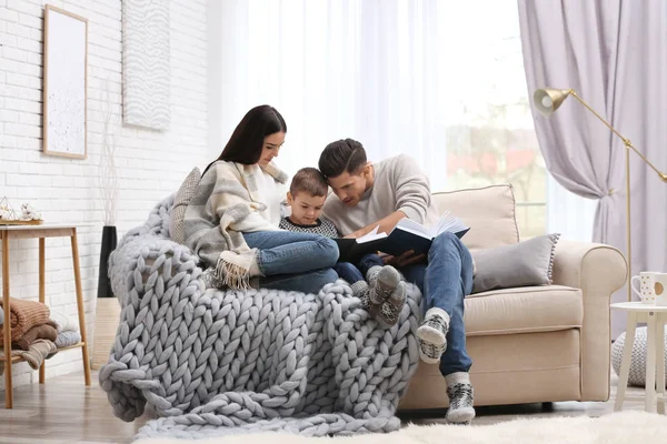 Glückliche Familie mit kleinem Sohn, der zu Hause Bücher liest. Winterurlaub — Stockfoto