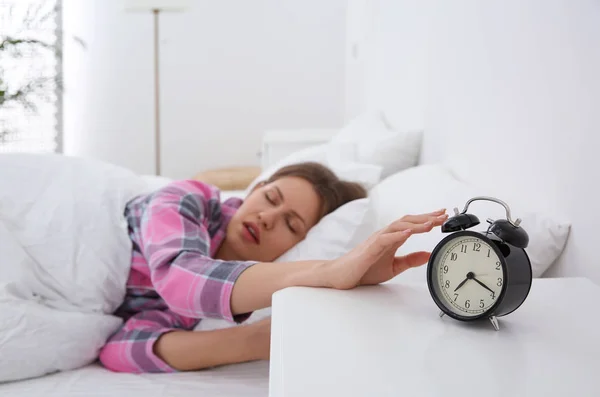 Álmos fiatal nő kikapcsolja ébresztőóra otthon reggel, f — Stock Fotó