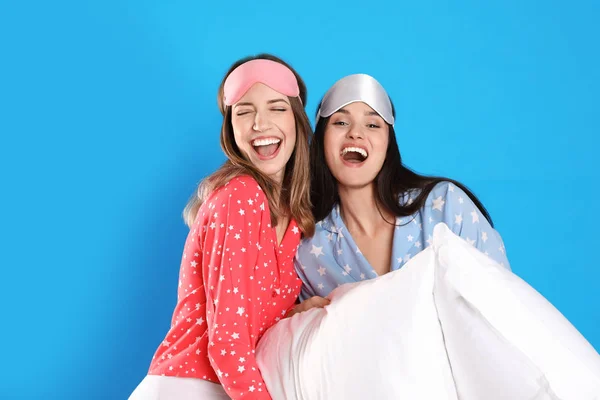 Hermosas mujeres con almohadas sobre fondo azul claro. Hora de dormir — Foto de Stock