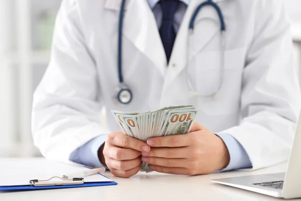 Doutor com suborno na mesa na clínica, close up. Medicamento corrompido — Fotografia de Stock