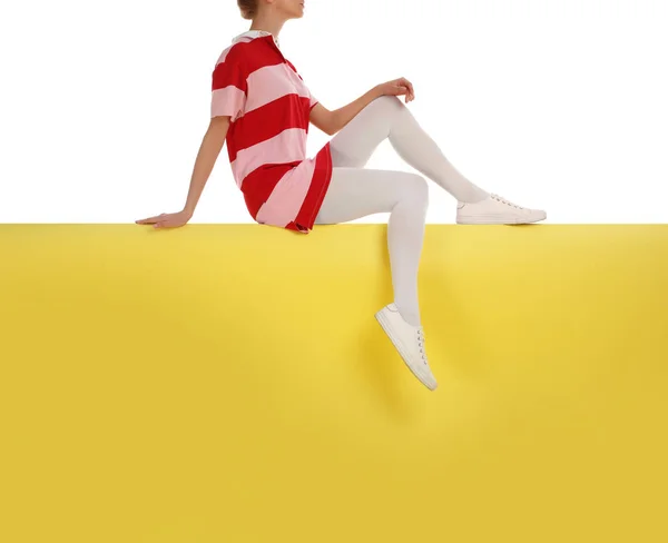 Kobieta w białych rajstopach i stylowe buty siedzi na ba kolor — Zdjęcie stockowe