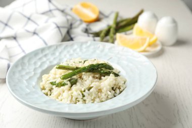 Beyaz ahşap masada kuşkonmaz ile nefis risotto.