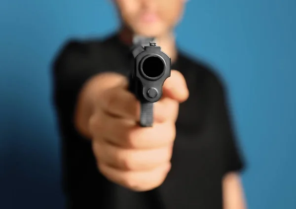 Человек Пистолетом Синем Фоне Крупным Планом — стоковое фото