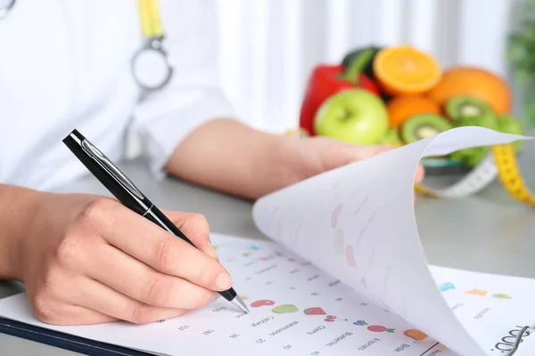 Vrouwelijke Voedingsdeskundige Met Lijst Van Producten Aan Tafel Close — Stockfoto