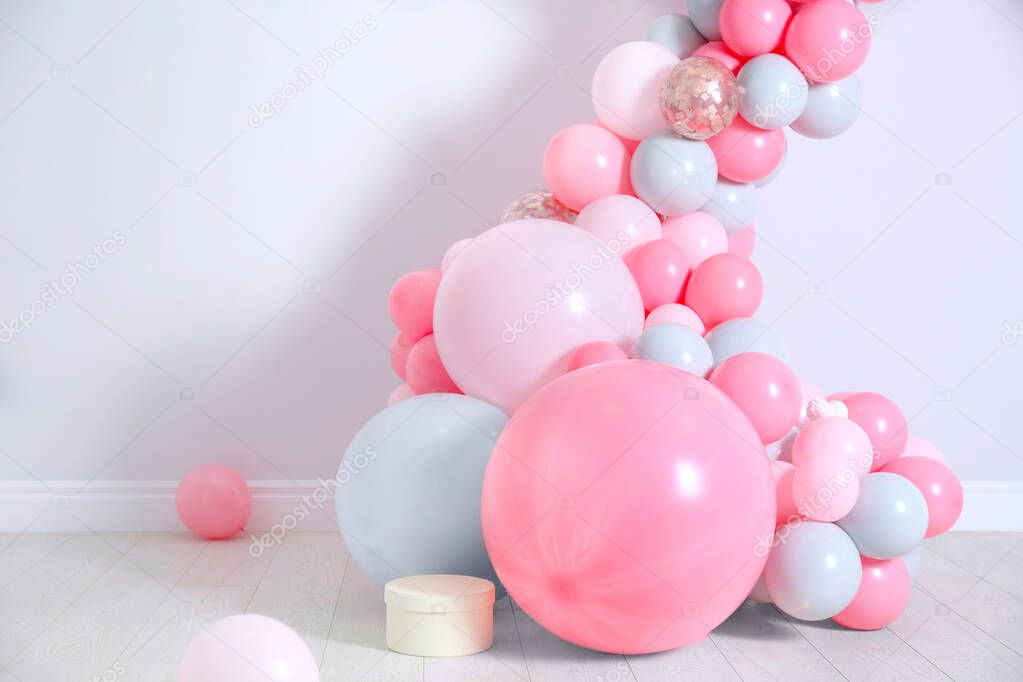 Beautiful composition with balloons near light wall