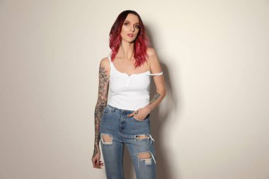 Kollarında hafif arka planda dövmeleri olan güzel bir kadın.