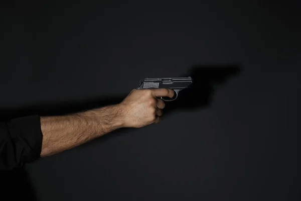 Profi gyilkos pisztollyal fekete háttér, közelkép — Stock Fotó