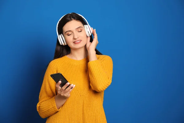 Young Woman Listening Audiobook Blue Background Space Text — 스톡 사진
