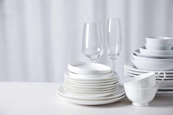 Набор чистой посуды на белом столе — стоковое фото