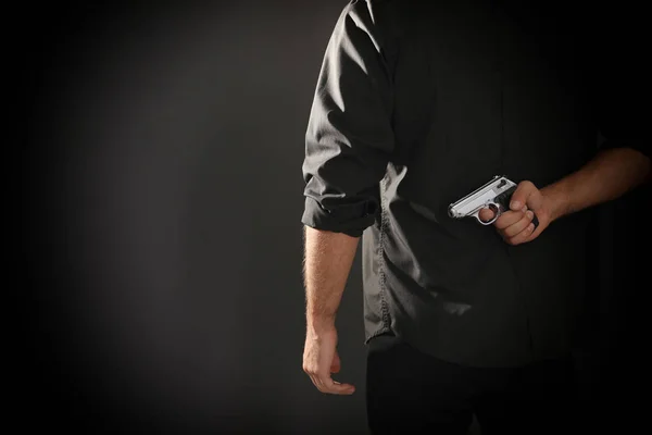 Asesino profesional con pistola sobre fondo negro, primer plano. Espacio — Foto de Stock