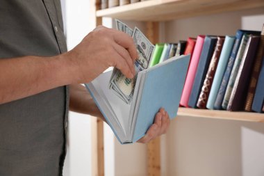 Kapalı mekanda para saklayan adam, yakın plan. Finansal tasarruflar