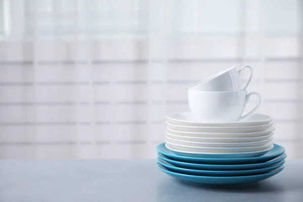 Set of clean tableware on light grey table. Space for text — ストック写真