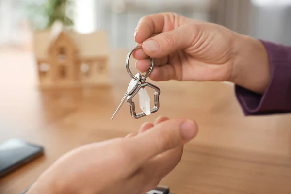 Immobilienmakler Übergibt Schlüssel Mit Schmuckstück Klientin Büro Nahaufnahme — Stockfoto