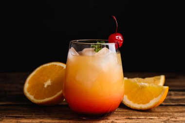 Taze alkolik Tekila Gün Doğumu kokteyli ahşap masada.