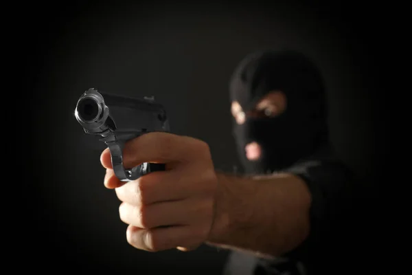 Assassino profissional em fundo preto, foco na arma — Fotografia de Stock