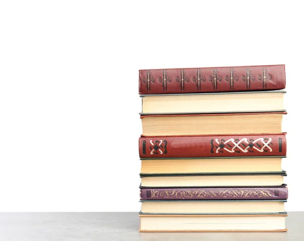 Stapel oude vintage boeken op stenen tafel tegen witte achtergrond — Stockfoto