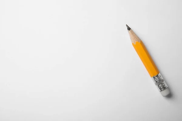 Гострий графітовий олівець на білому тлі, вид зверху. Простір для t — стокове фото