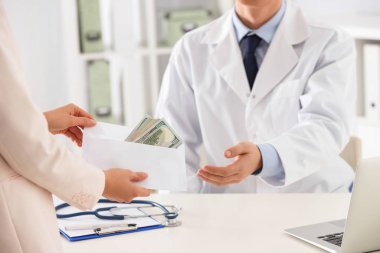 Hasta klinikteki doktora rüşvet veriyor, yakın plan. Yozlaşmış tıp