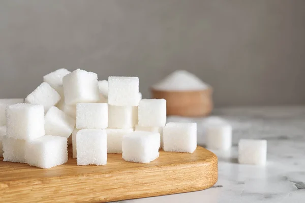 Утонченные кубики сахара на белом мраморном столе — стоковое фото