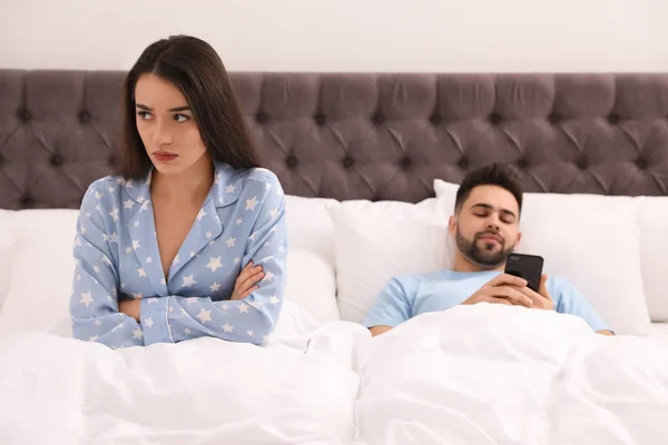 年轻人喜欢在床上用智能手机，而不喜欢在床上用女朋友 — 图库照片