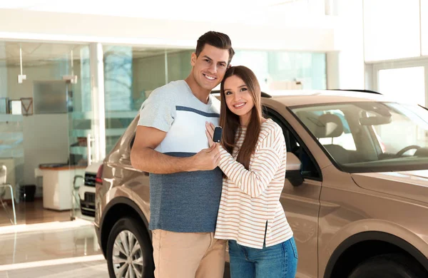 Coppia Felice Con Chiave Della Macchina Nella Moderna Concessionaria Auto — Foto Stock