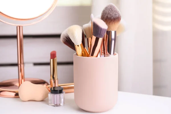 Set of professional makeup brushes in holder on dressing table — Stock Photo, Image