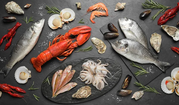 Frischer Fisch Und Verschiedene Meeresfrüchte Auf Schwarzem Tisch Flach Gelegt — Stockfoto