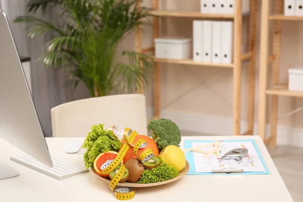 Lugar de trabajo del nutricionista con frutas, verduras, cinta métrica —  Fotos de Stock