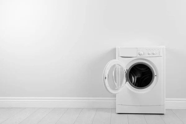Beyaz duvarın yanında modern çamaşır makinesi, yazı için yer var. Çamaşır. — Stok fotoğraf