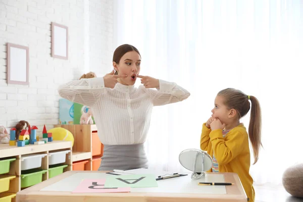 Terapeuta del habla trabajando con una niña en la oficina —  Fotos de Stock