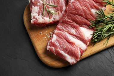 Biberiyeli çiğ pirzola ve siyah masanın üstünde tuz.