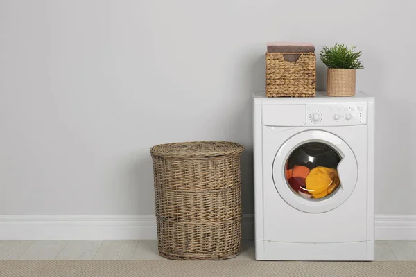 Modern mosógép mosodával, szobanövényekkel és fonott kosárral — Stock Fotó