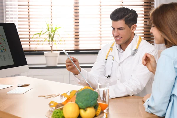Nutritionniste consultant patient à table en clinique — Photo