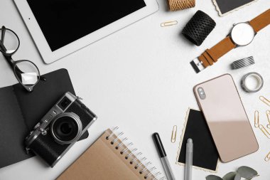 Klasik kamera, akıllı telefon ve tabletle bembeyaz masada düz kompozisyon, mesaj için boşluk. Tasarımcının işyeri