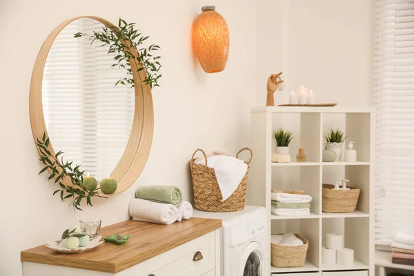 Round mirror on white wall in modern bathroom