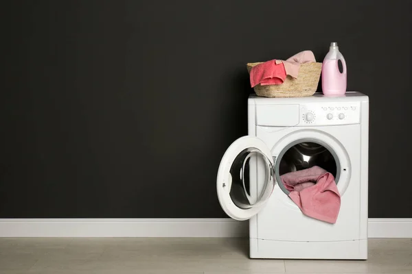 Máquina de lavar roupa moderna com lavanderia, cesta de vime e detergente — Fotografia de Stock