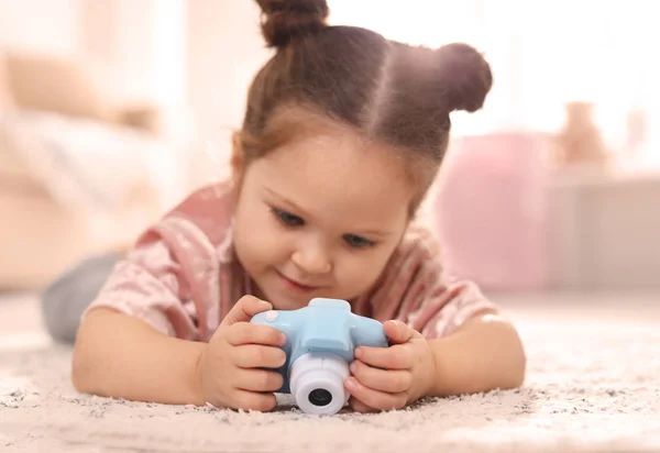 Liten fotograf med leksakskamera på golvet hemma — Stockfoto