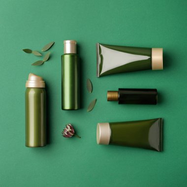 Yeşil zemin üzerinde kozmetik ürünleri ile düz kompozisyon