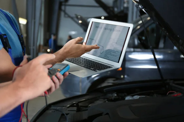 Mecânica com laptop fazendo diagnóstico de carro no reparo de automóveis — Fotografia de Stock